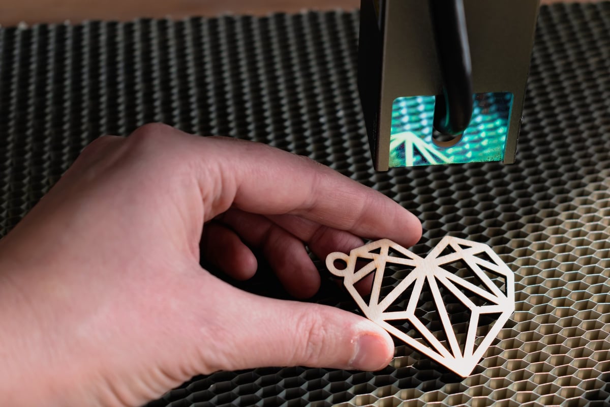 Laser engraving and cutting, a woman holding a laser-cut wooden heart piece